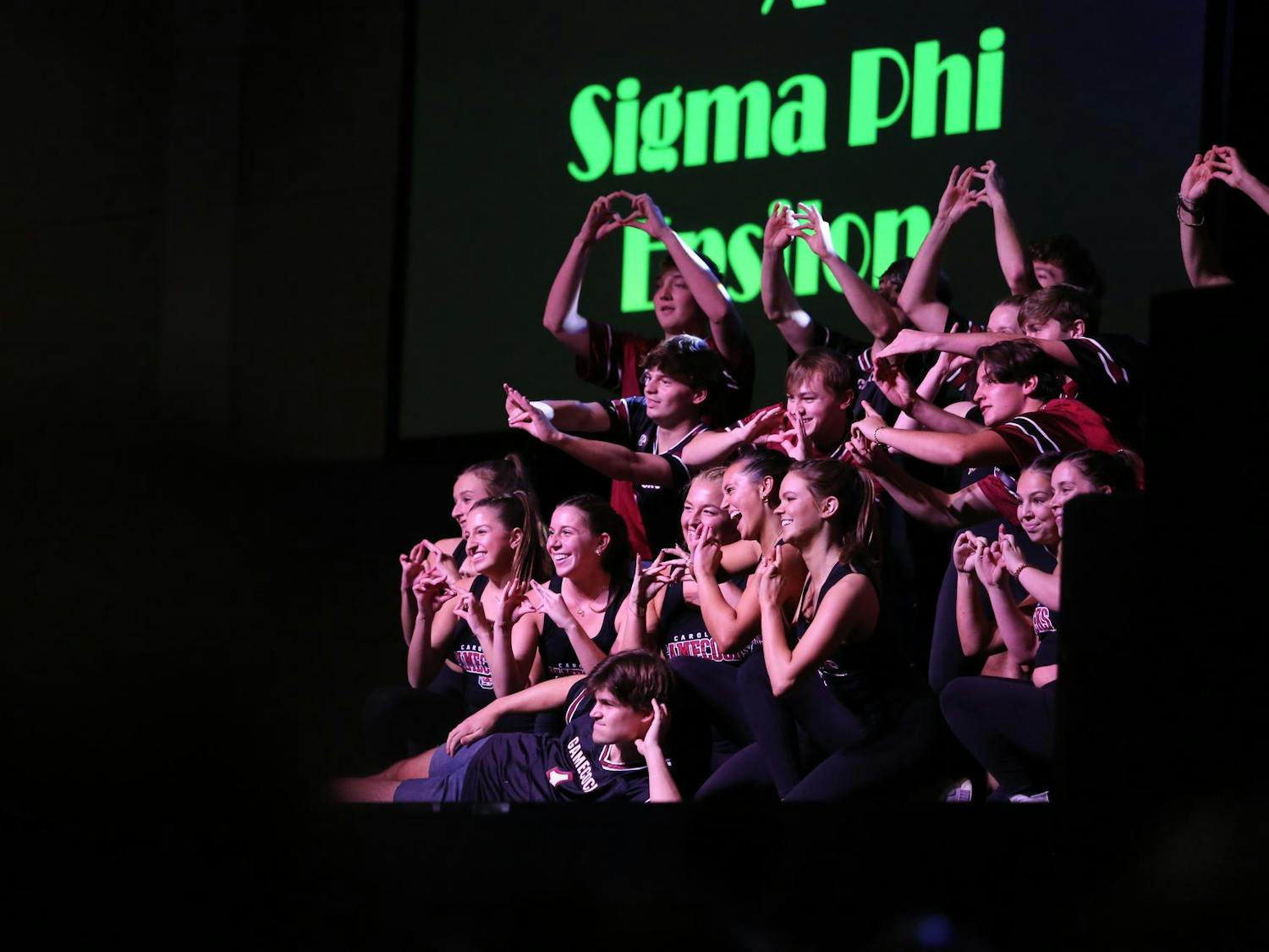 Brothers of Sigma Phi Epsilon and sisters of Phi Mu pose at the end of their performance at Spurs and Struts on Oct. 11, 2023. Each member of the team held up the sign of their sorority or fraternity.