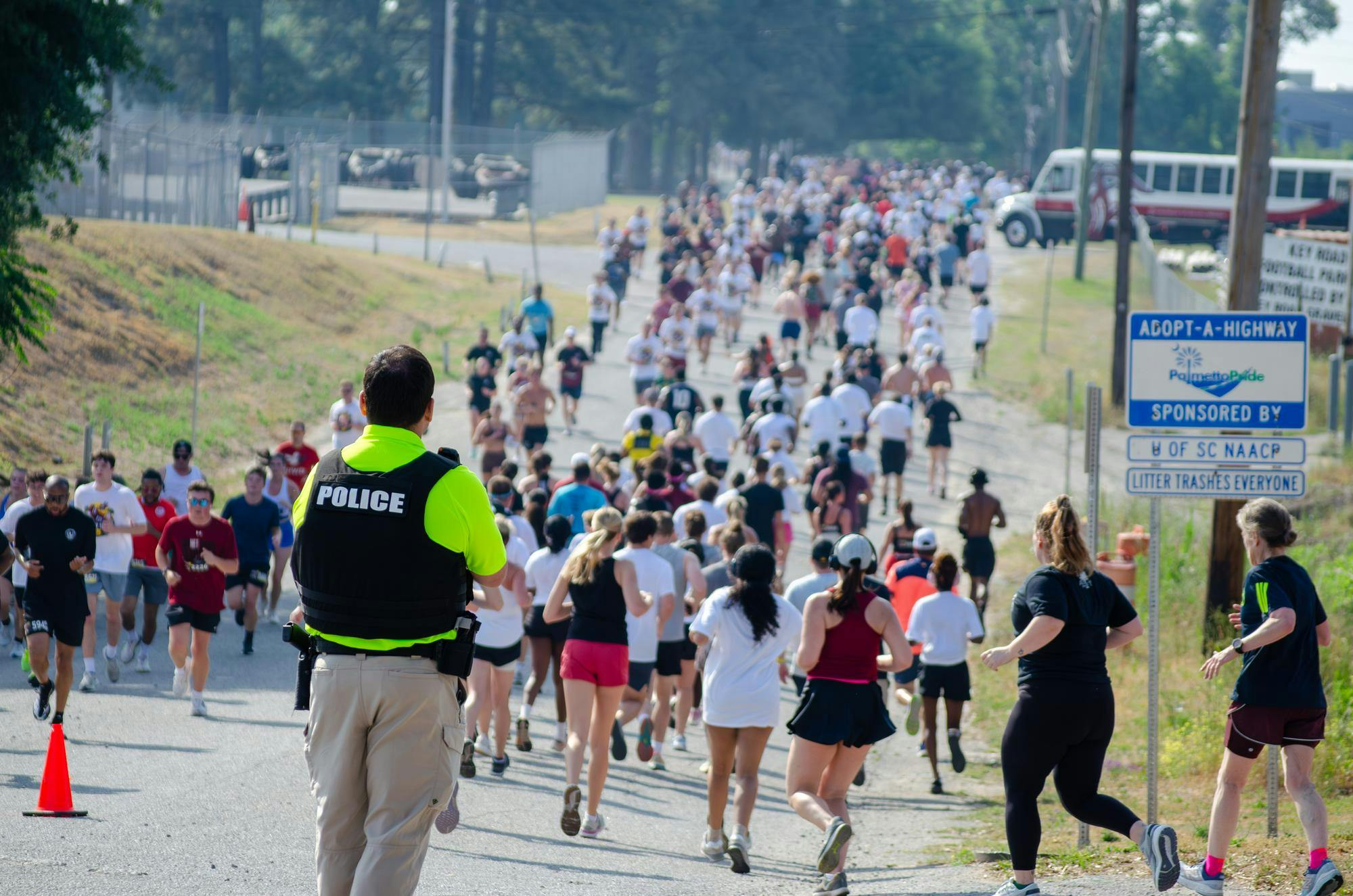 A police officer watches as participants of the fifth annual Cocky Trot 5K run in both directions on Key Road on April 25, 2026. Officers and volunteers were stationed all along the route and encouraged runners often by clapping or shouting.