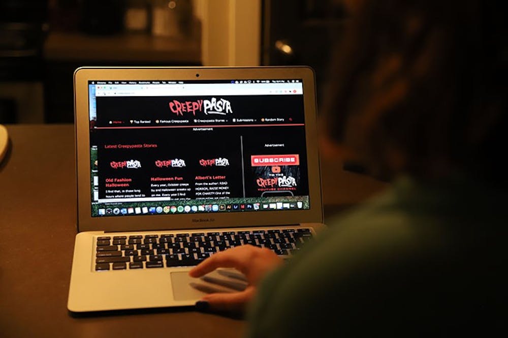  A person at a computer while it is displaying the Creepypasta website. Creepypasta is a horror story website where writers can post stories and receive feedback from their audience.