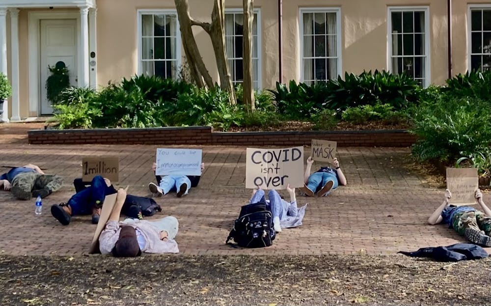 <p>Protestors lay with signs on the Horseshoe at the University of South Carolina on Thursday, March 31, 2022. The protest was held to speak out against the recent removal of UofSC's mask mandate.</p>