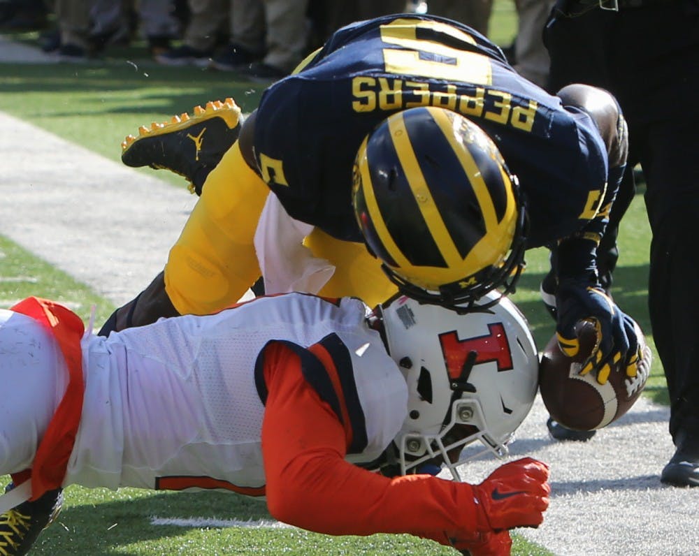Michigan's Jabrill Peppers (5) is tackled by Illinois' Stanley Green in the first quarter on Saturday, Oct. 22, 2016, at Michigan Stadium in Ann Arbor, Mich. The host Wolverines won, 41-8. (Kirthmon F. Dozier/Detroit Free Press/TNS)