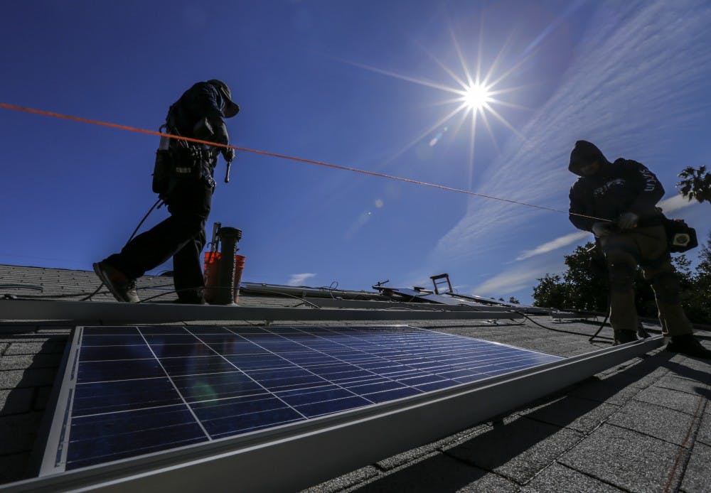 A crew installs solar panels on a home in Los Angeles in February 2016. (Irfan Khan/Los Angeles Times/TNS)