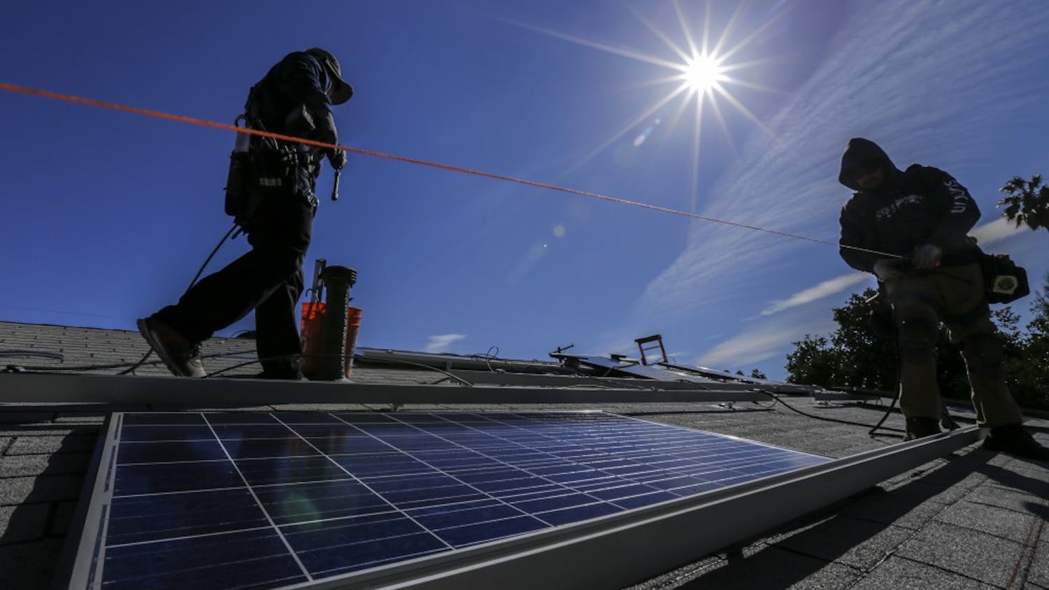 A crew installs solar panels on a home in Los Angeles in February 2016. (Irfan Khan/Los Angeles Times/TNS)