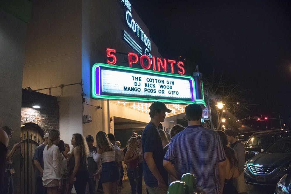 The street view of The Cotton Gin bustling with college students at night.&nbsp;
