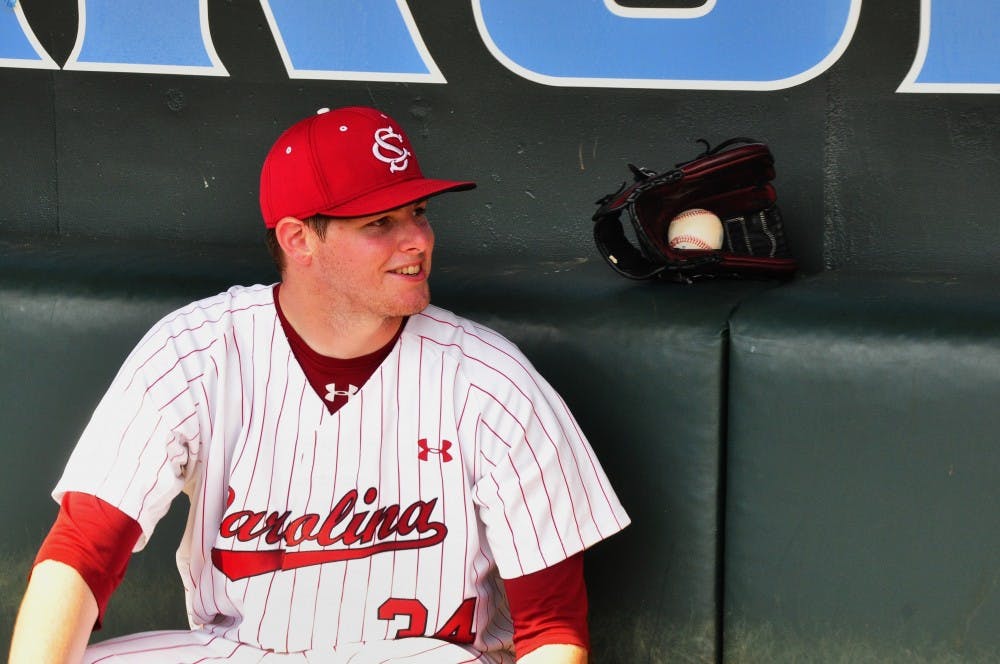 Gamecocks pitcher Jason Montgomery relaxes in the dugout after the game with the game ball.