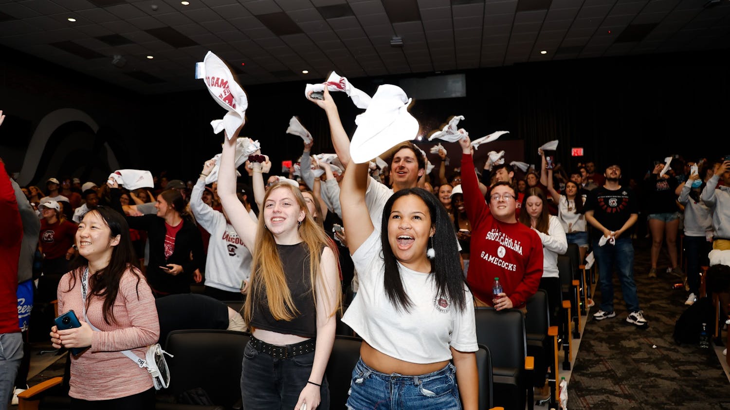Students cheer and wave their rally towels in the Russell House theater after the women’s basketball team beats the University of Connecticut in the NCAA championship game on April 3, 2022, in Columbia, SC.