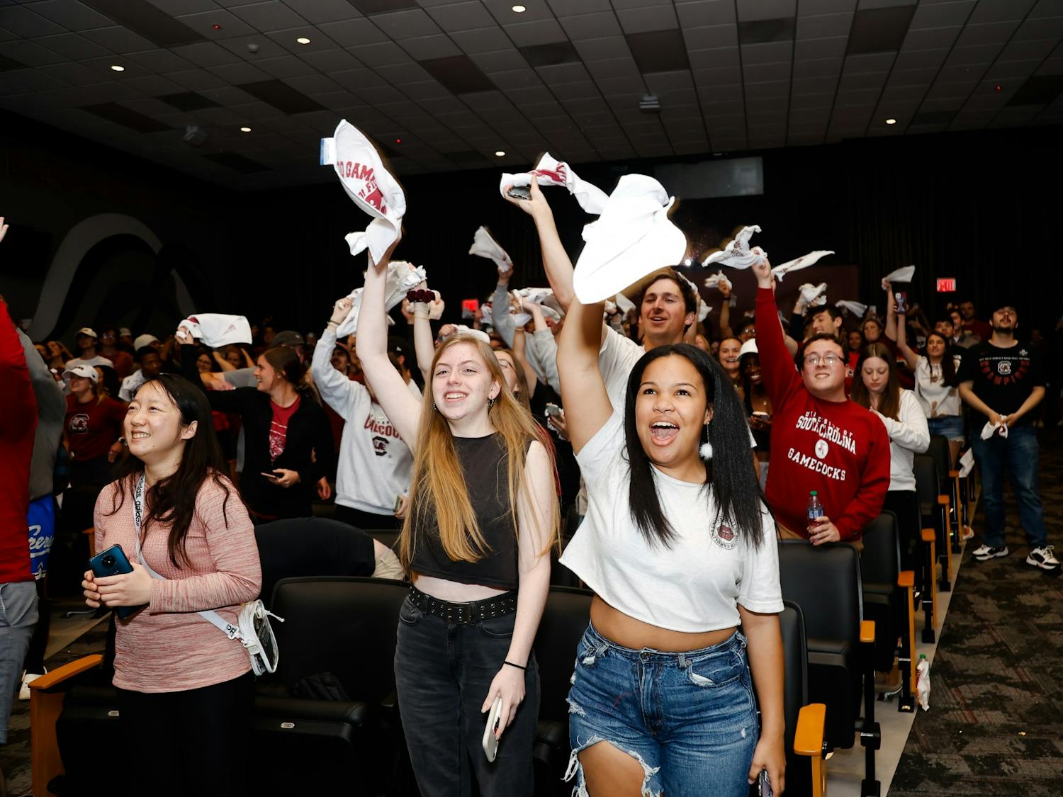 Students cheer and wave their rally towels in the Russell House theater after the women’s basketball team beats the University of Connecticut in the NCAA championship game on April 3, 2022, in Columbia, SC.