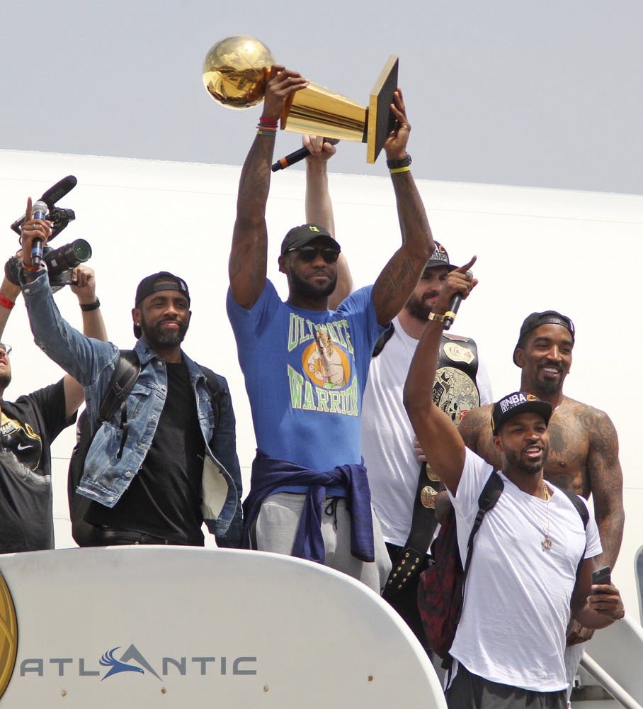 Cleveland Cavaliers' LeBron James holds up the NBA Championship trophy alongside teammates on JUne 20, 2016 after arriving in Cleveland, Ohio. Joining James are Kyrie Irving, left, Kevin Love, J.R. Smith and Tristan Thompson as they arrive at Atlantic Aviation. (Mike Cardew/Akron Beacon Journal/TNS )