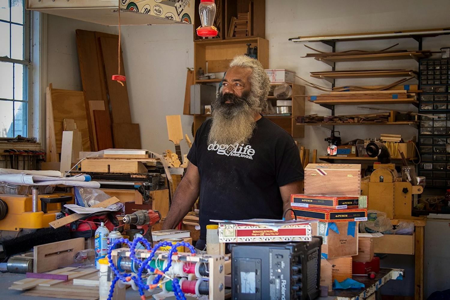 Anthony Walker stands in the garage of his home behind his work bench. Walker currently makes cigar box guitars out of his home and sells them at Soda City market March through December.&nbsp;