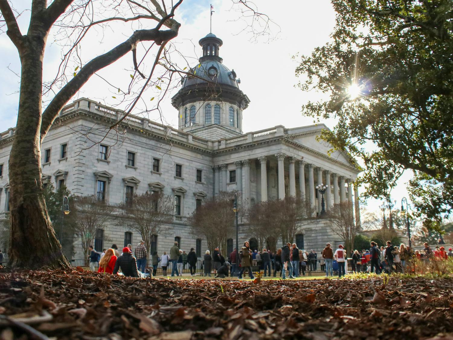 Former President Donald Trump arrived for his first campaign trip at the South Carolina Statehouse on Jan. 28, 2023. Although the event was limited to 500 guests, this boundary — and the fence — did not stop Trump supporters from showing their adoration for the potential 2024 presidential candidate. Aside from a few verbal altercations between a Trump supporter and a trio of counter protestors, the day was peaceful. As the sun set over the Statehouse, people pulled out their phones and streamed Trump's message, experiencing the event in their own way — on the other side of the fence.&nbsp;