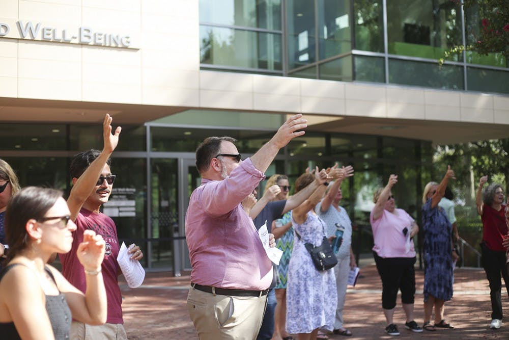 Rally attendees sing the alma mater at the end of the rally at Russell House on Wednesday.&nbsp;