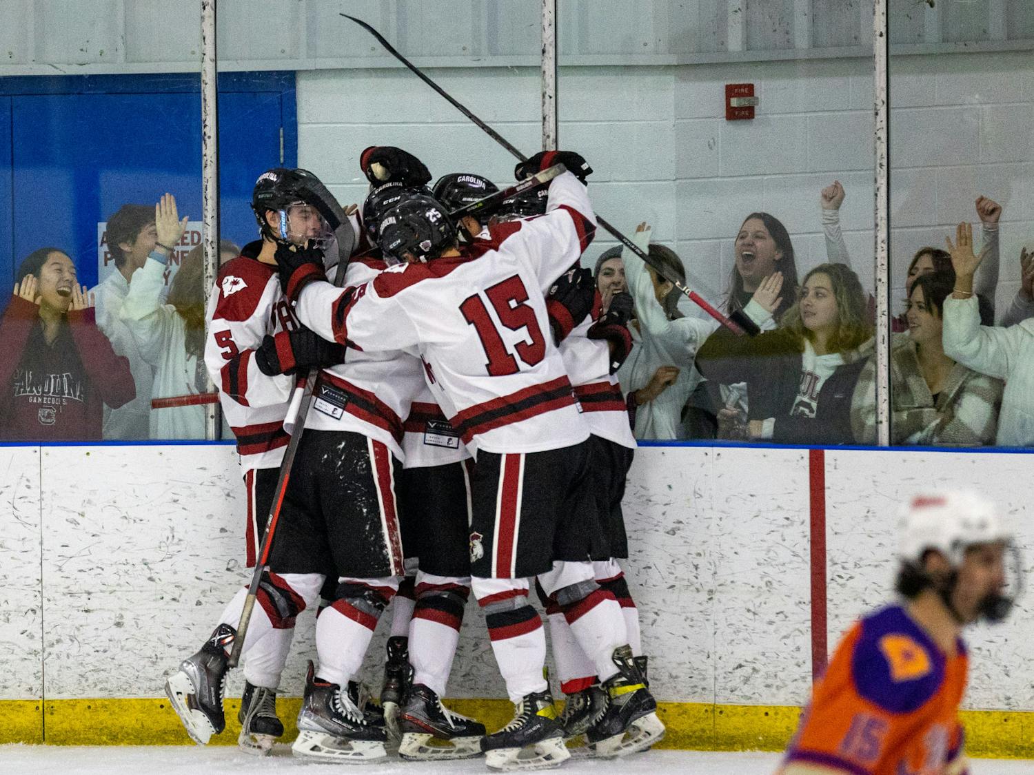 A group of South Carolina hockey players led by junior defenseman Bobby DiCicco celebrate following a goal against the Tigers on Nov. 11, 2022. As South Carolina continues its winning streak after defeating Clemson, fans pile against the glass cheering on the team.&nbsp;