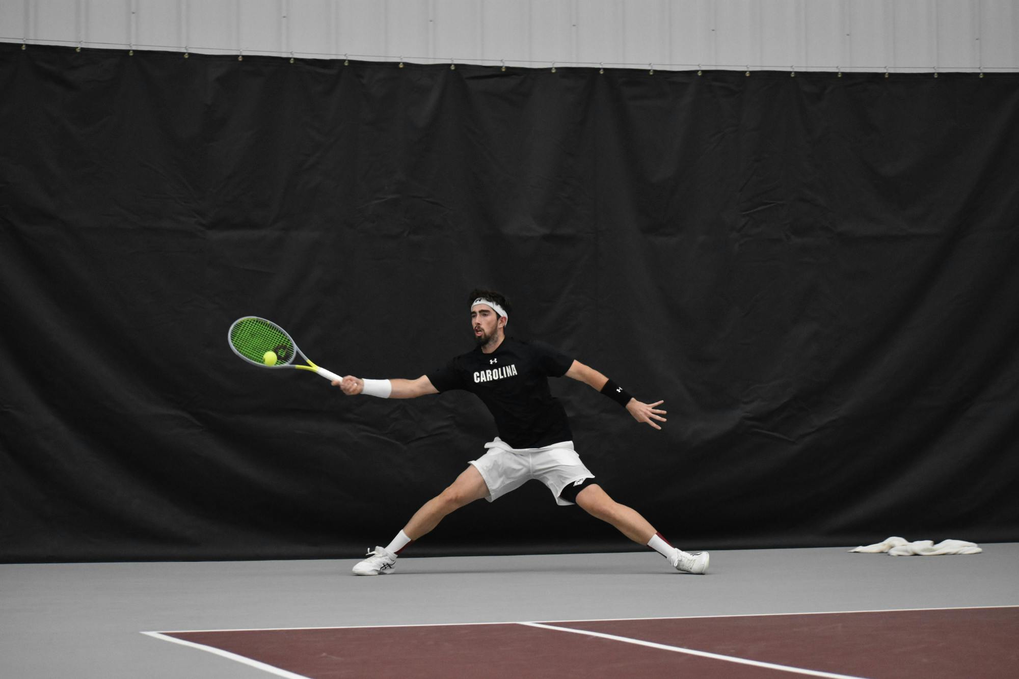 Junior Connor Thomson lunges to return the ball during his singles match on day two of the ITA Kickoff Weekend event at the Carolina Indoor Tennis Center on Jan. 29, 2023. The South Carolina Gamecocks beat N.C. State 4-0, making it the winner of the ITA tournament.&nbsp;