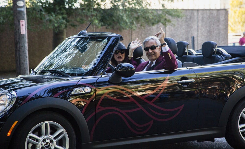 <p>President Emeritus Harris Pastides and his wife Patricia Moore-Pastides ride in a car in the 2017 Homecoming parade.</p>