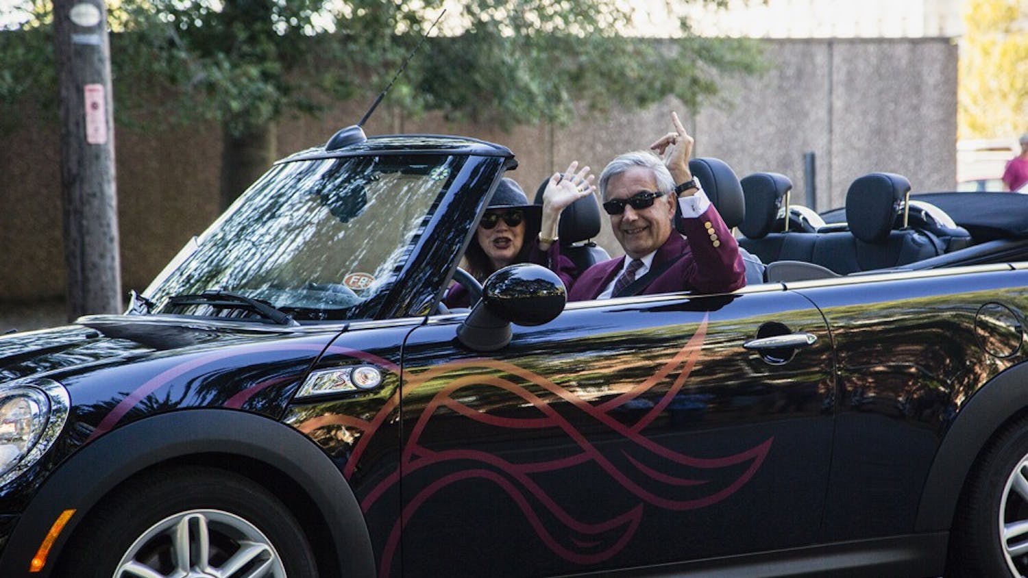 President Emeritus Harris Pastides and his wife Patricia Moore-Pastides ride in a car in the 2017 Homecoming parade.