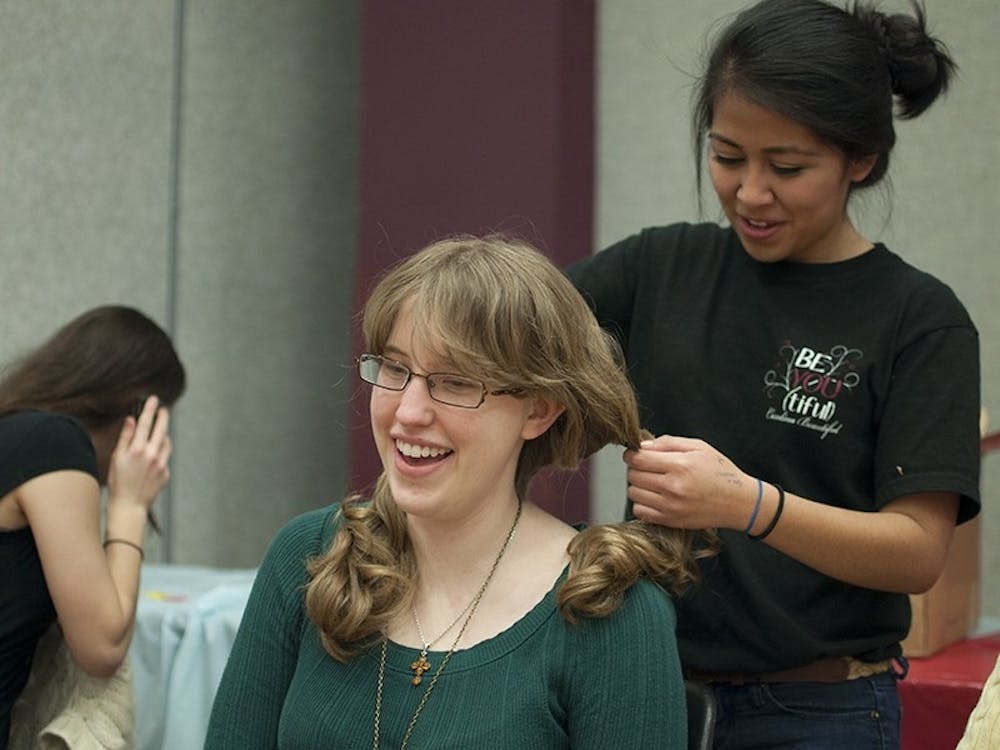 Kali Esancy, a fourth-year biology and French student, has her hair cut in the Russell House Ballroom Sunday evening.