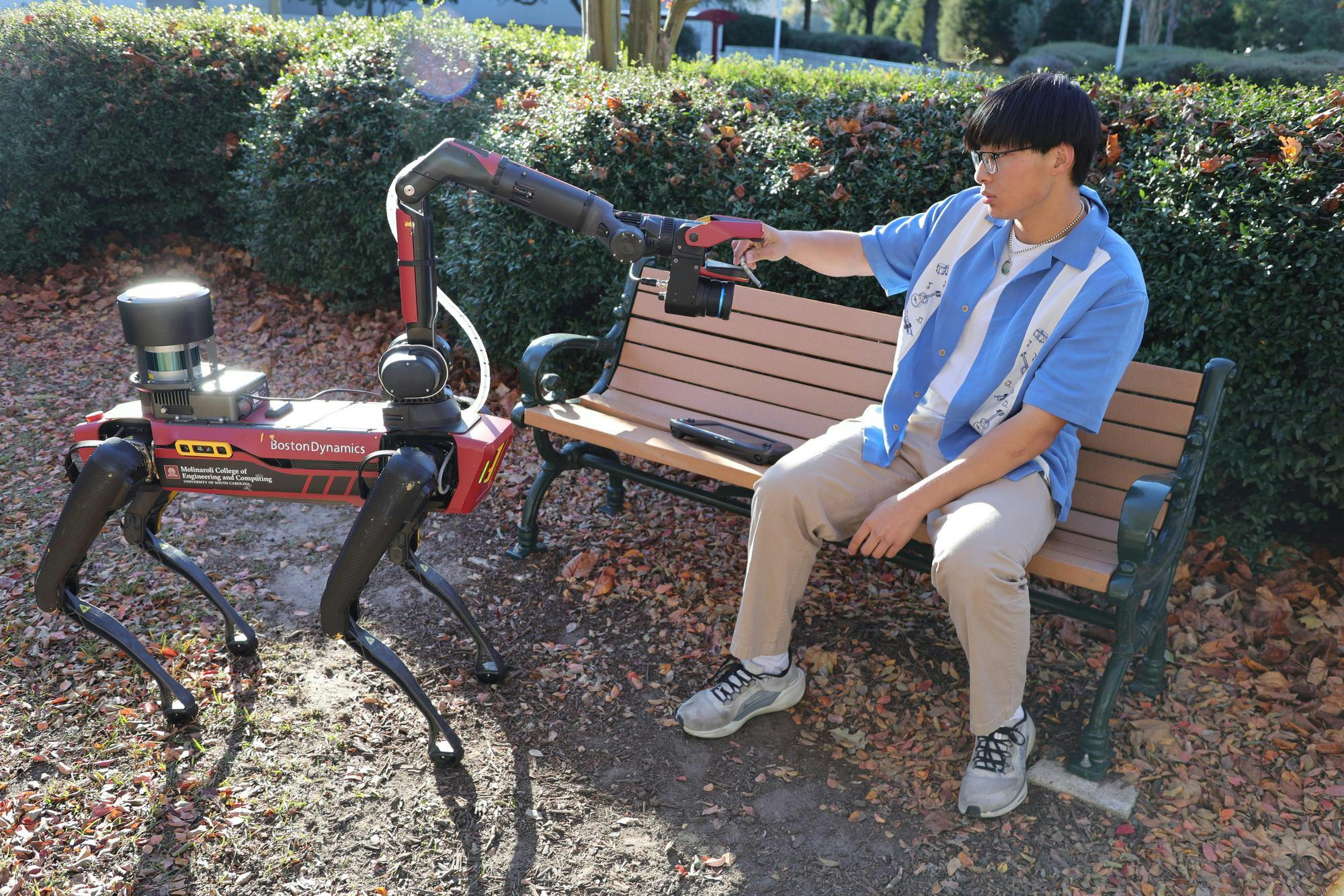 Second-year advertising student Jason Wu tests Spot’s mechanical arm outside the Swearingen Engineering Center on Nov. 12, 2025. Spot’s design allows for precise motion control used in demonstrations for USC engineering students.