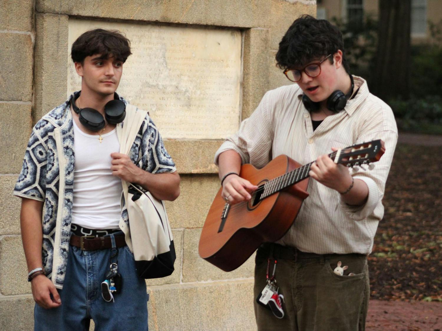 A contestant in the Performative Male Contest, plays a song on his acoustic guitar to the audience. He competed along with many others at the Horseshoe on Sept. 20, 2025.