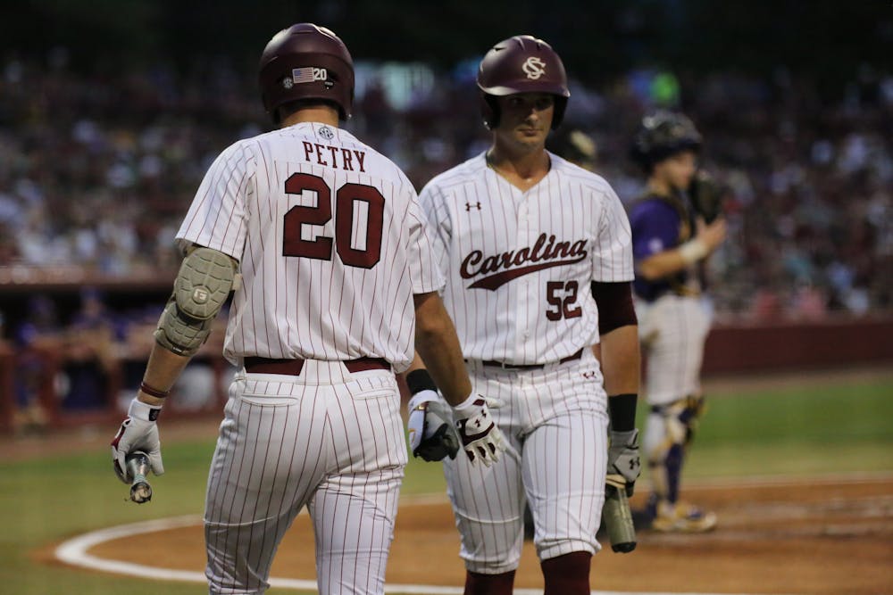 <p>Freshman outfielder Ethan Petry high fives junior first baseman Gavin Casas as he walks up to the plate to hit for the Gamecocks. No. 6 South Carolina won the first game of a three-game series 13-5 against No. 1 LSU on April 6, 2023, at Founders Park.</p>