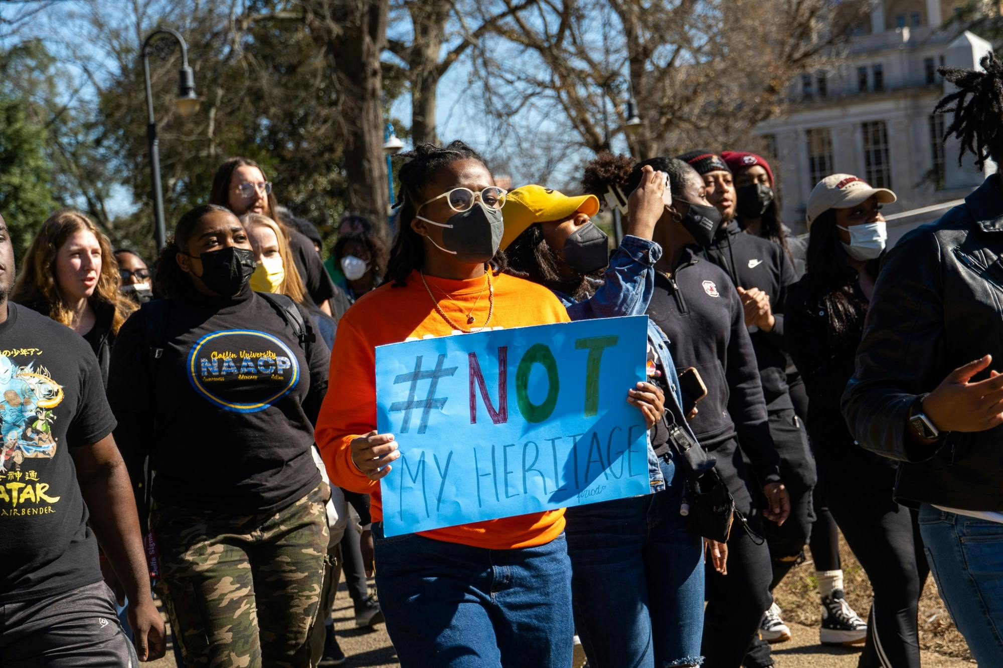 The protesters made their way to the front of the statehouse carrying signs that voiced their disdain for the S.C. Heritage Act and the figures it serves to protect on Feb. 5, 2022. Some signs from the events the protesters carried read '#NotMyHeritage,' 'Aim to Rename,' and 'Silence is Violence.'