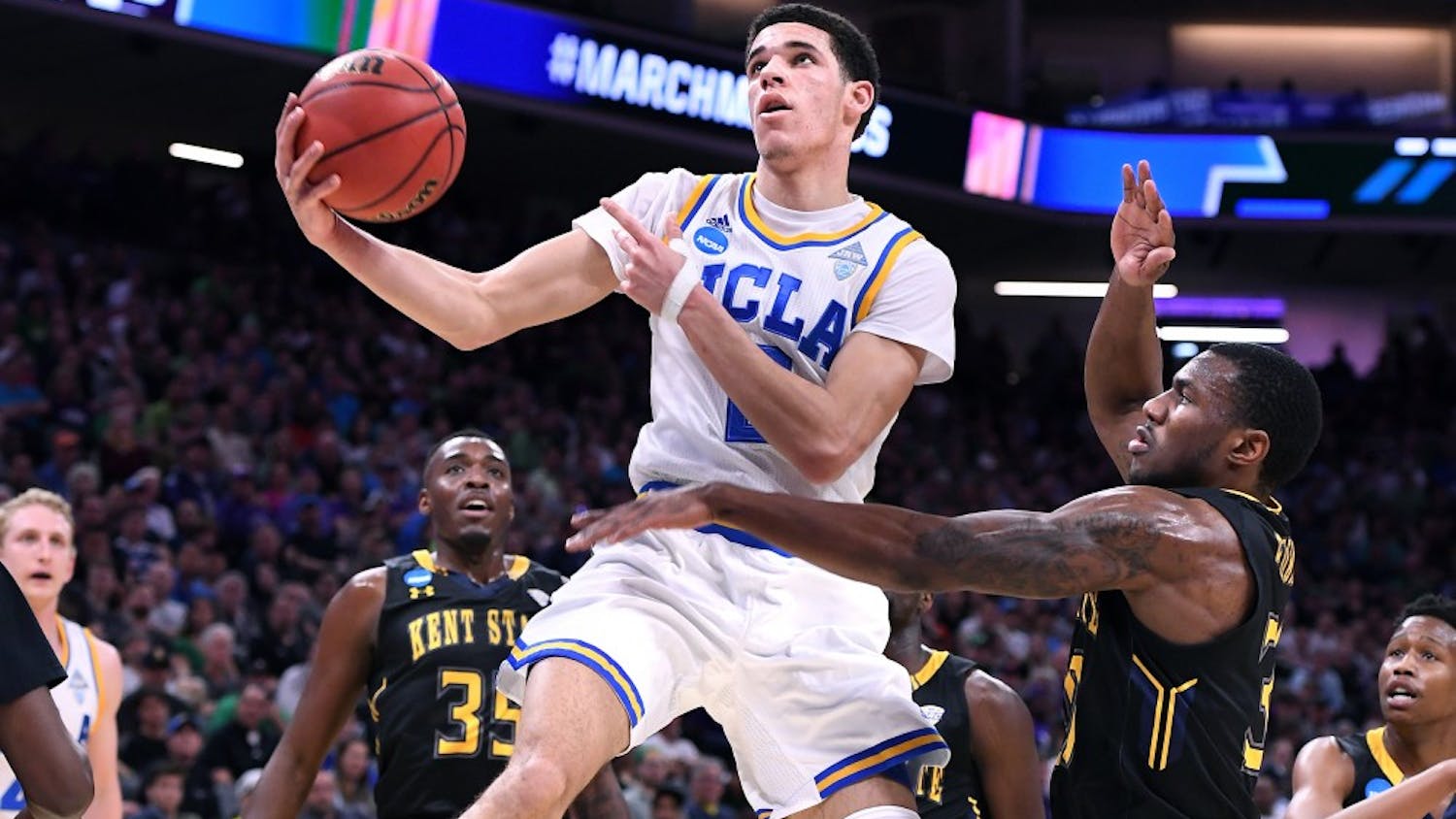 UCLA's Lonzo Ball, middle, scores a basket and draws a foul against Kent State's Kevin Zabo during the first half in the first round of the NCAA Tournament at the Golden 1 Center in Sacramento, Calif., on Friday, March 17, 2017. UCLA advanced, 97-80. (Wally Skalij/Los Angeles Times/TNS)