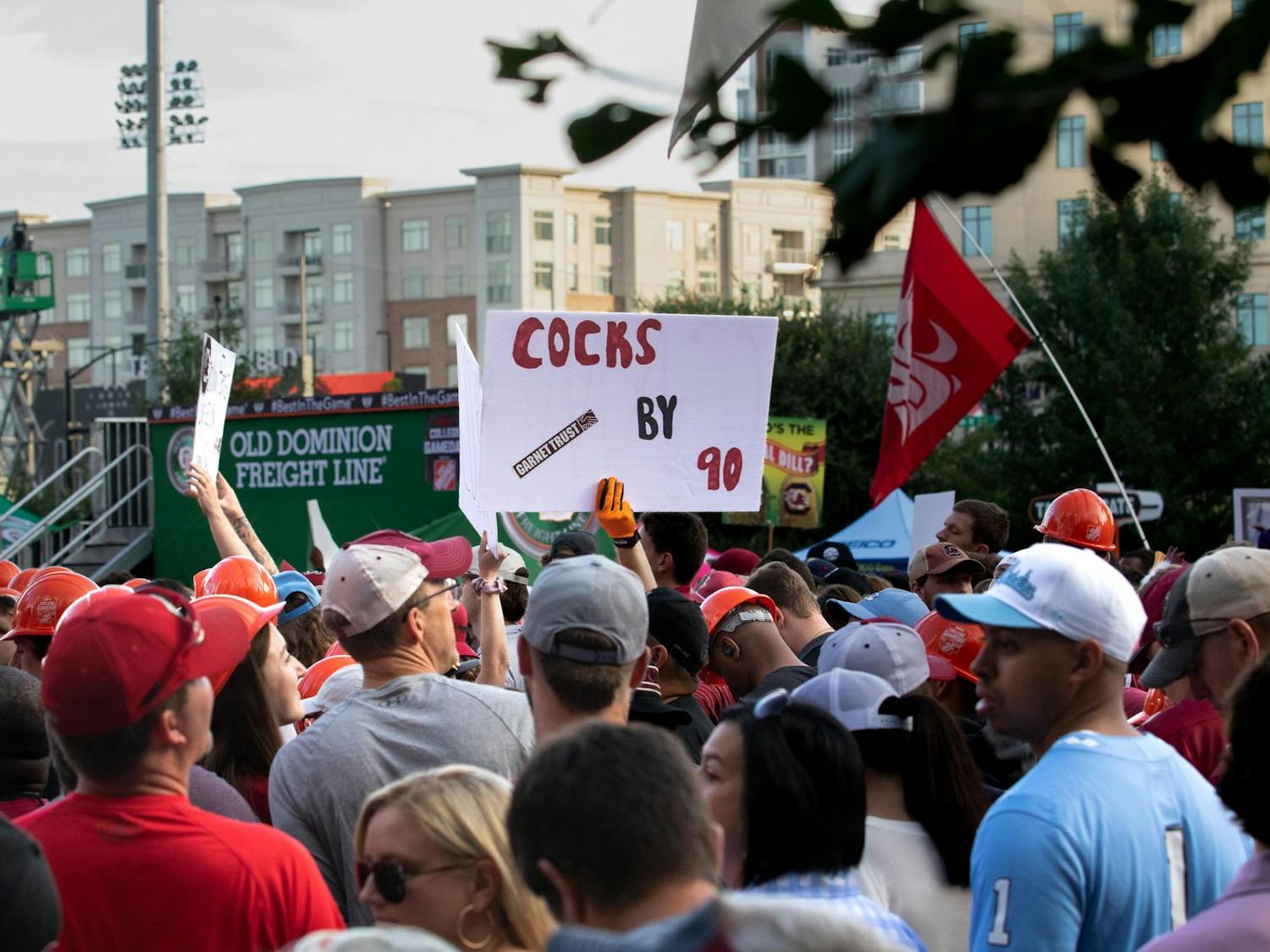 A “Cocks by 90” sign is displayed above thousands of fans gathered for College GameDay. “Cocks by 90” is a slogan used by Gamecocks fans to express confidence in the team's chance of winning.