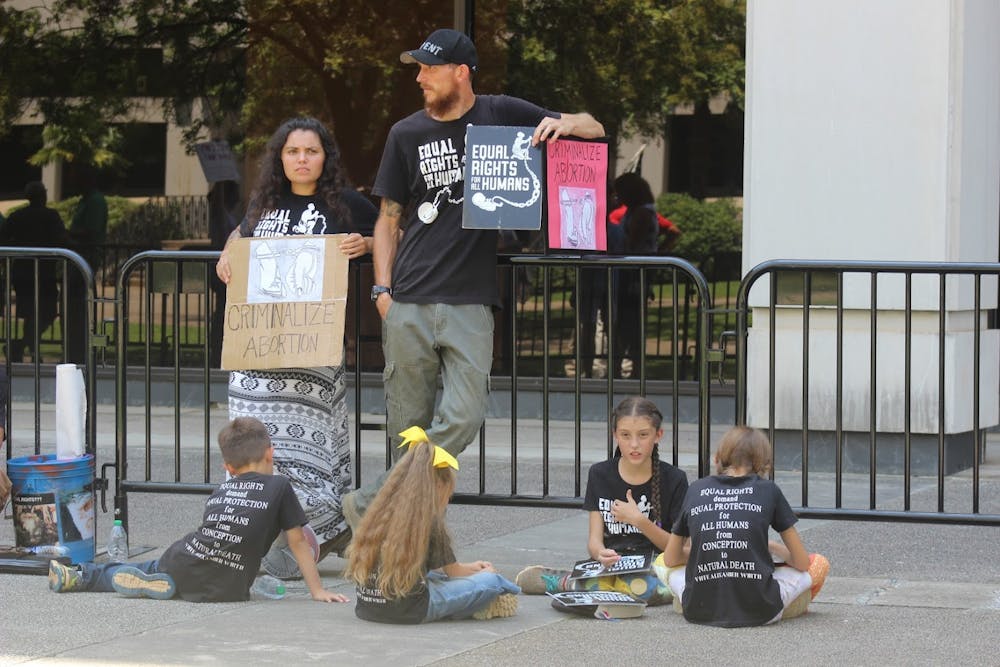 <p>Annie Wirth and her husband call for abortion to be criminalized. Activists gathered outside the Statehouse July 7 to voice their opinion on the state's abortion laws.</p>