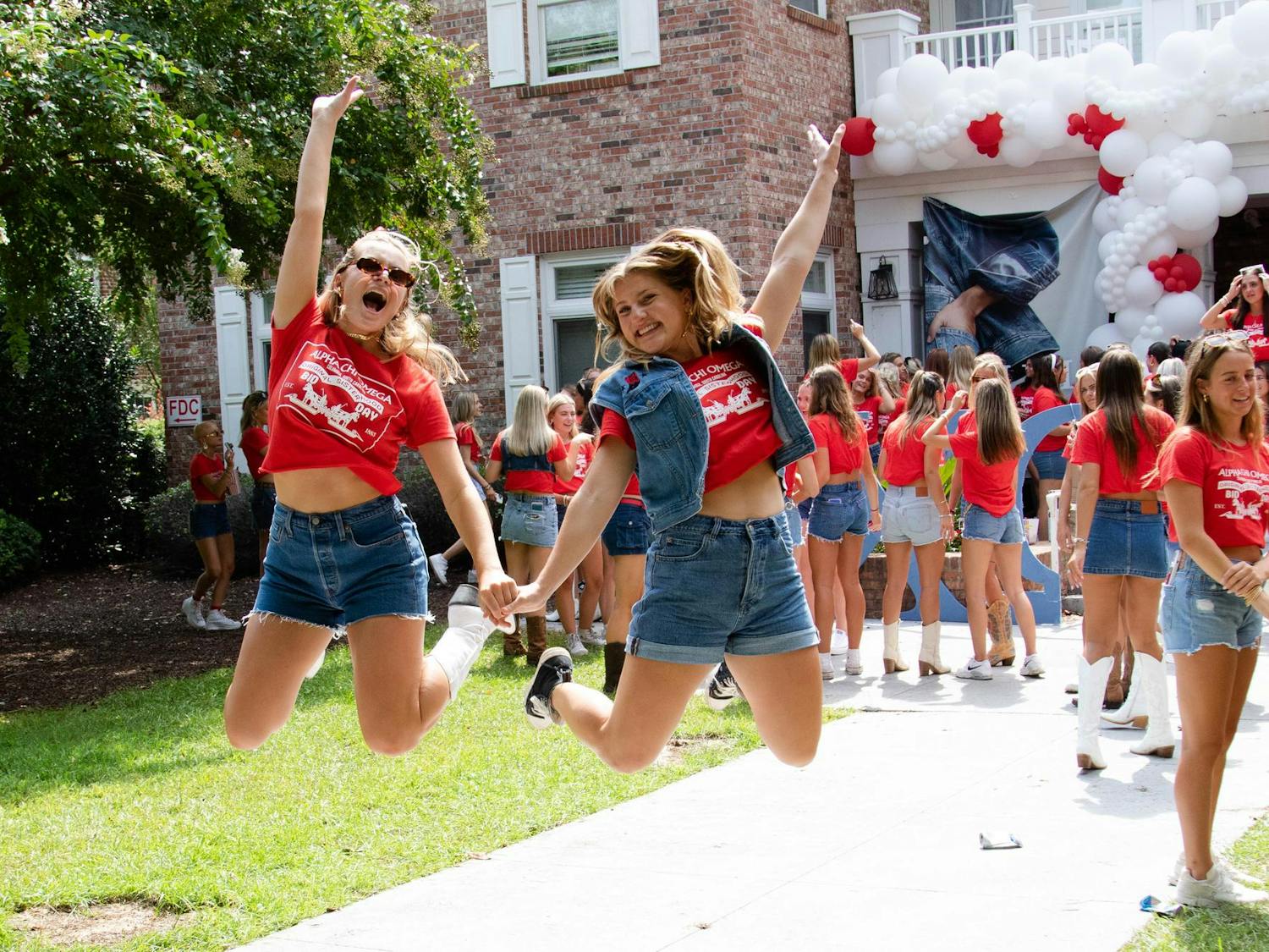 Members of Alpha Chi Omega jump for a picture on Aug. 27, 2023. The chapter dressed in denim for its Bid Day theme while celebrating its new pledge class.