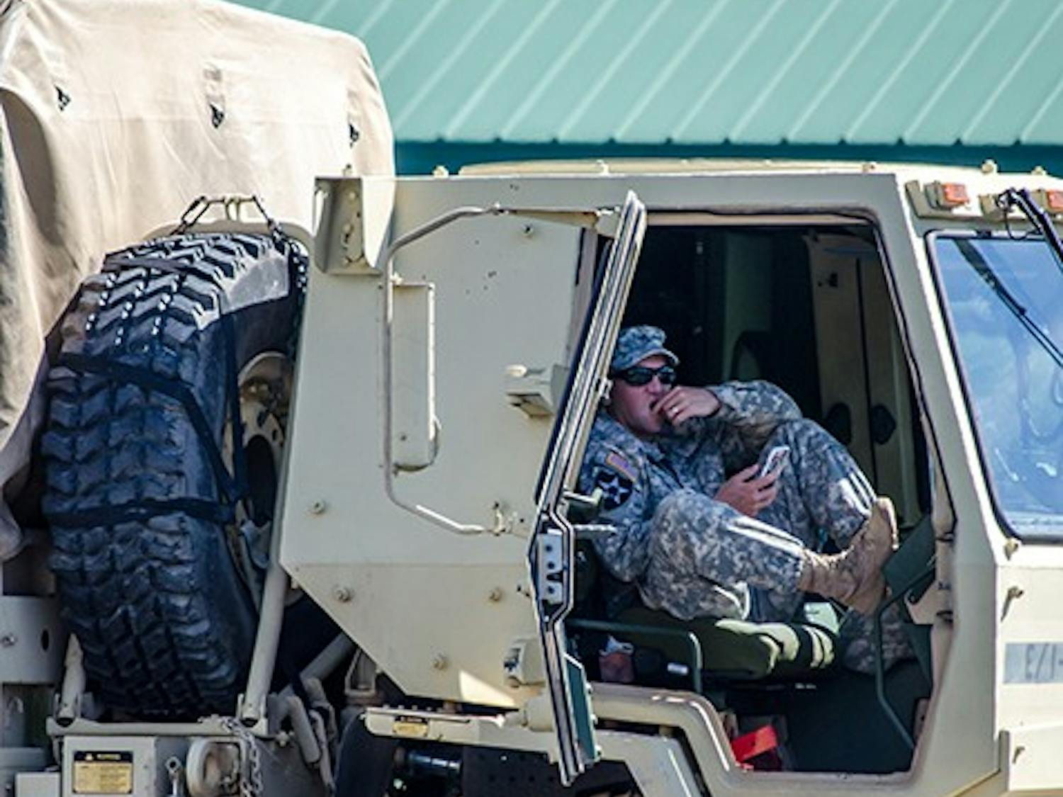 Member of the National Guard takes a moment to rest at the Bi Lo parking lot on Forest Drive, October 6. 