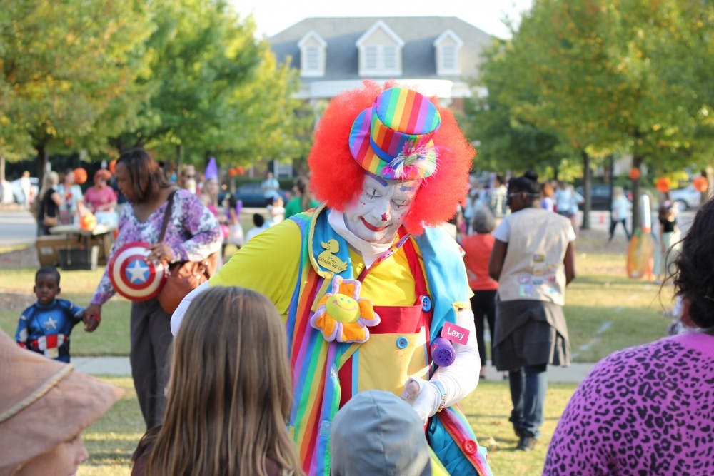A clown makes balloon animals for the children at Trick-or-Treat with the Greeks.