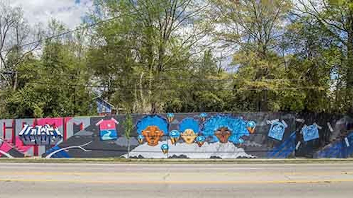 Photo of the triptych mural on Millwood Avenue. This mural was created by Karl Zurfluh, Brandon Donahue and Cedric Umoja.