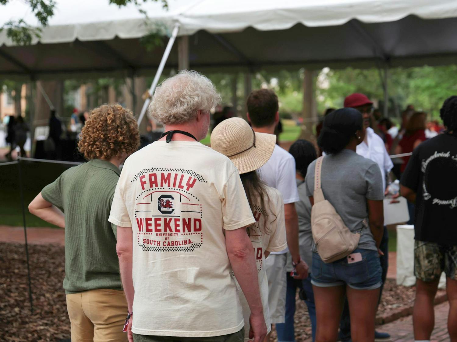 A visitor wearing a “Family Weekend” shirt waits in line to meet the president of the university at the Horseshoe on Sept. 20, 2024. The event, which served as the first of many throughout Family Weekend, allowed families to meet and talk with USC’s President Michael Amiridis.