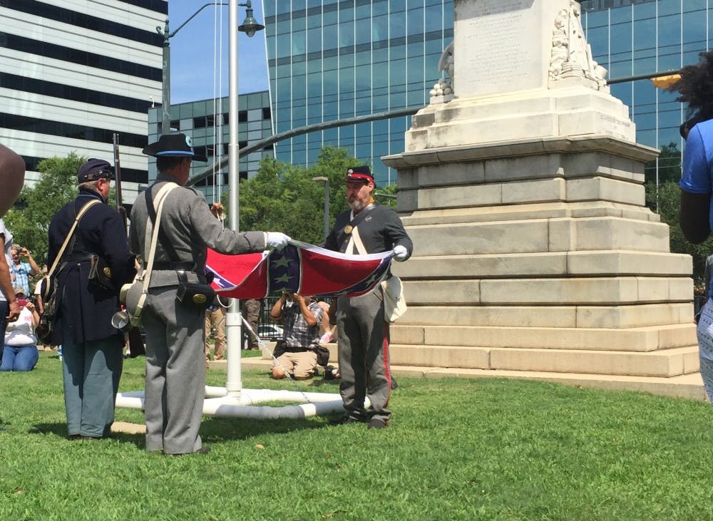 <p>Confederate flag supporters in Civil War re-enactment uniforms ceremonially raise the battle flag at a rally on Statehouse grounds on July 10, 2016.</p>
