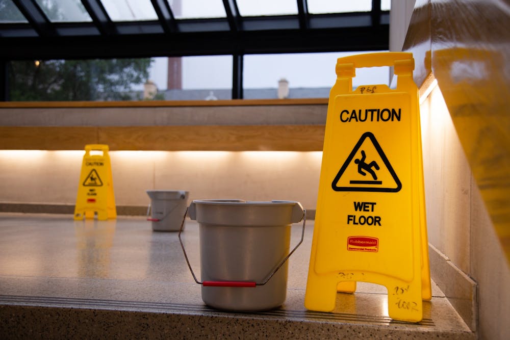 <p>A picture of caution signs and buckets on the steps of the Russell House on July 5, 2022. The buckets were placed to catch water leaking from the ceiling due to heavy rain.&nbsp;</p>