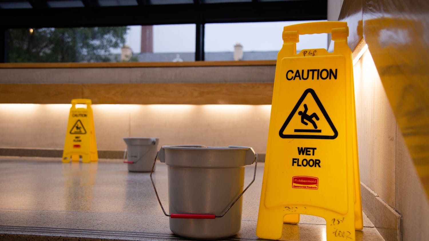 A picture of caution signs and buckets on the steps of the Russell House on July 5, 2022. The buckets were placed to catch water leaking from the ceiling due to heavy rain.&nbsp;