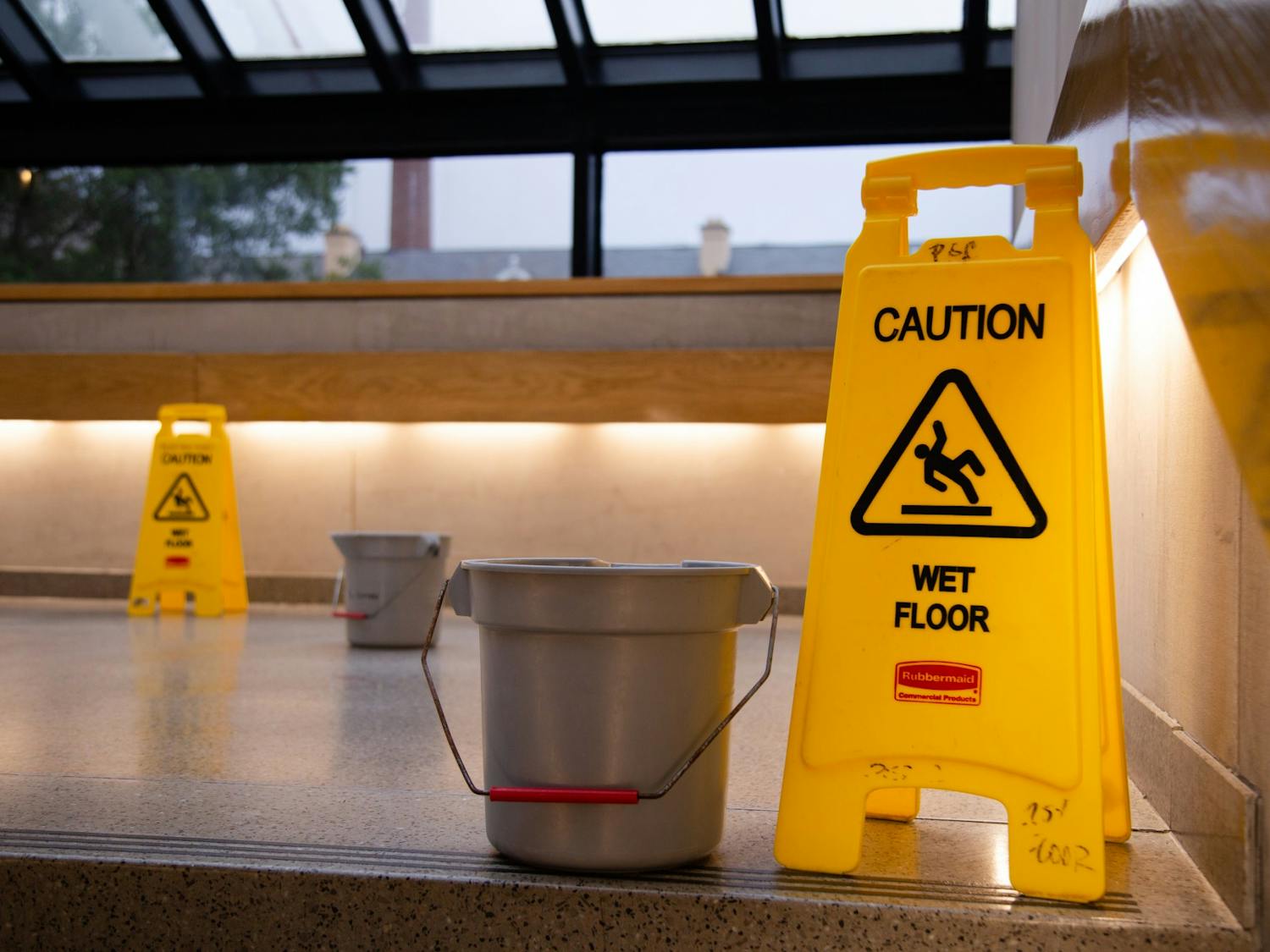 A picture of caution signs and buckets on the steps of the Russell House on July 5, 2022. The buckets were placed to catch water leaking from the ceiling due to heavy rain. 