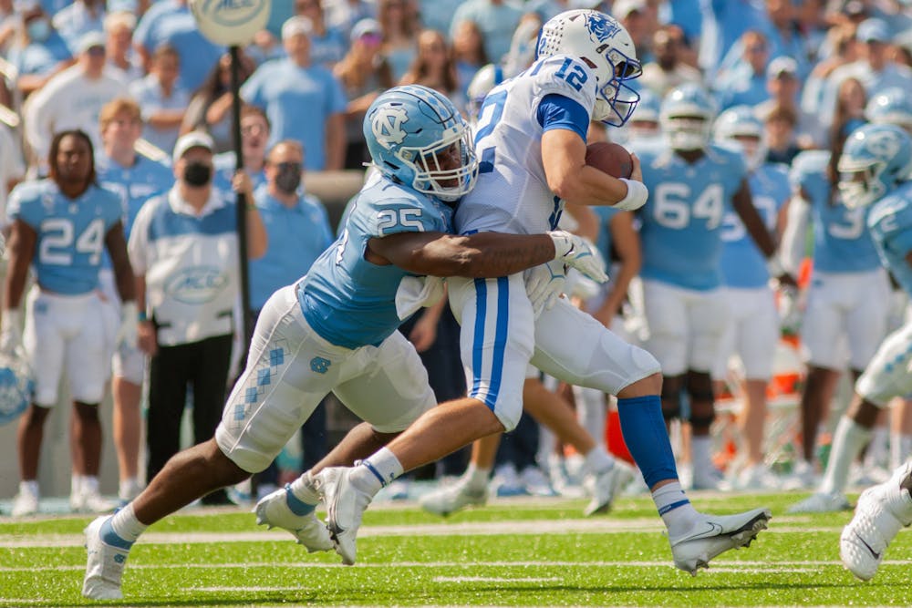 <p>UNC sophomore linebacker Kaimon Rucker (25) tackles a Duke player at the game against Duke at Kenan Stadium on Oct. 2, 2021. UNC won 38-7.</p>