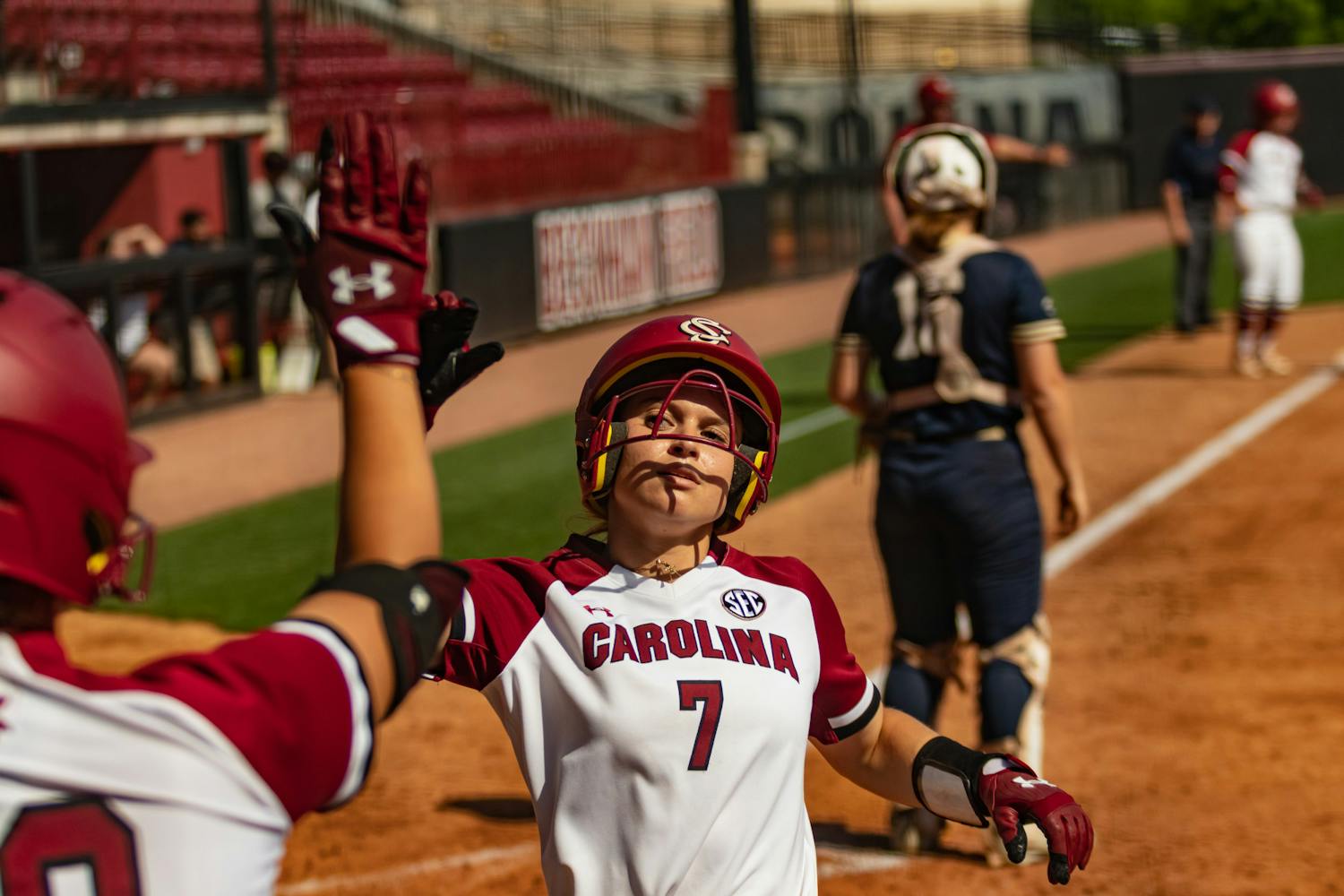 Sophomore catcher and infielder Giulia Desiderio scores and receives a high five from a teammate during the first game against Charleston Southern at Beckham Field on April 19, 2023. This was one of five runs that the Gamecocks scored against the Buccaneers, winning 5-0. &nbsp;