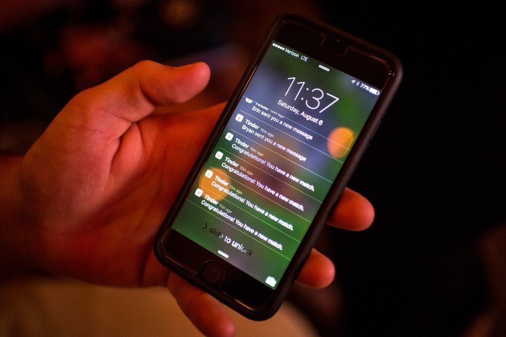 Michael Durand, of Rockford, Minn., checks his Tinder notifications late Saturday night, Aug. 6, 2016 at Cowboy Jack's in downtown Minneapolis.  (Aaron Lavinsky/Minneapolis Star Tribune/TNS) 