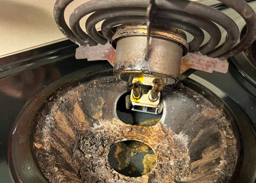 <p>Closeup of the oil and dirt residue left underneath a stovetop in an apartment at the Rowan apartment complex.</p>
