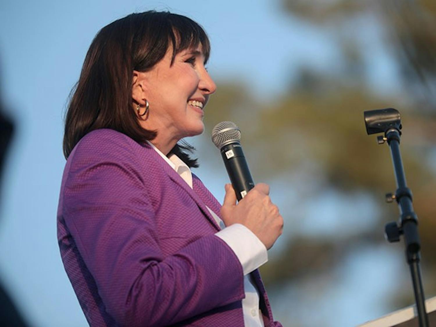 Libertarian presidential nominee Jo Jorgensen stands with a microphone in her hand.