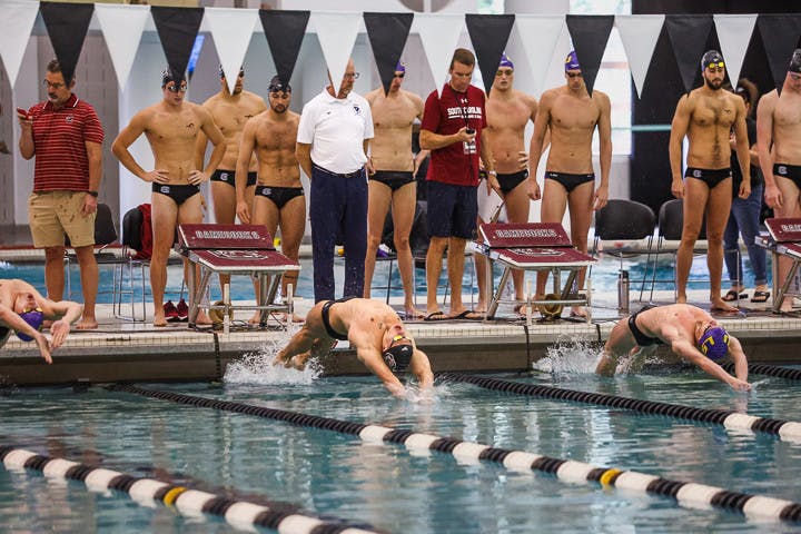 The South Carolina and LSU men's swim teams watch as the players kick off at the start of the 200-yard medley relay event on Oct. 8, 2022. The Gamecock men's swim team lost 143-157 to the Tigers.