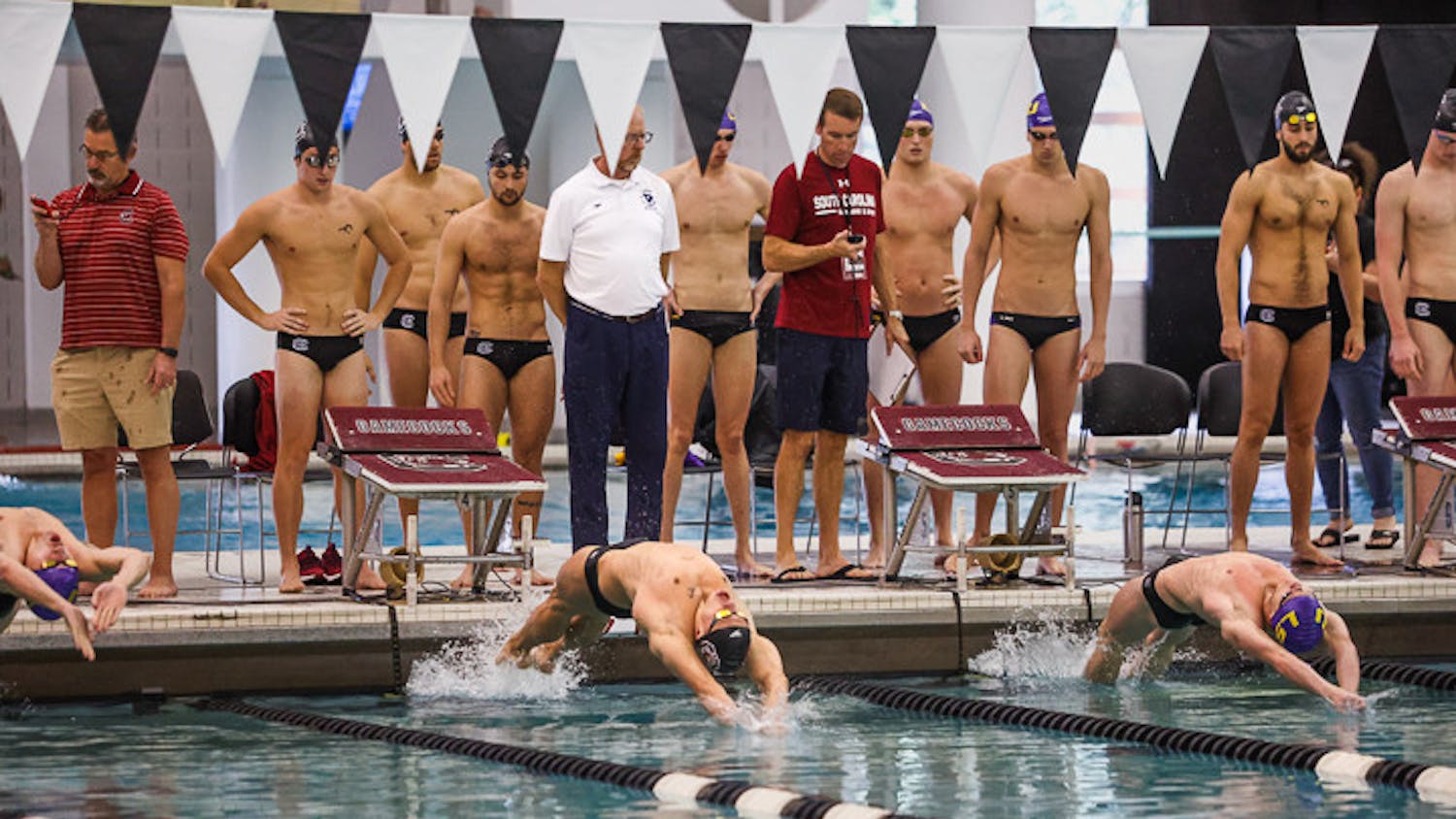 The South Carolina and LSU men's swim teams watch as the players kick off at the start of the 200-yard medley relay event on Oct. 8, 2022. The Gamecock men's swim team lost 143-157 to the Tigers.