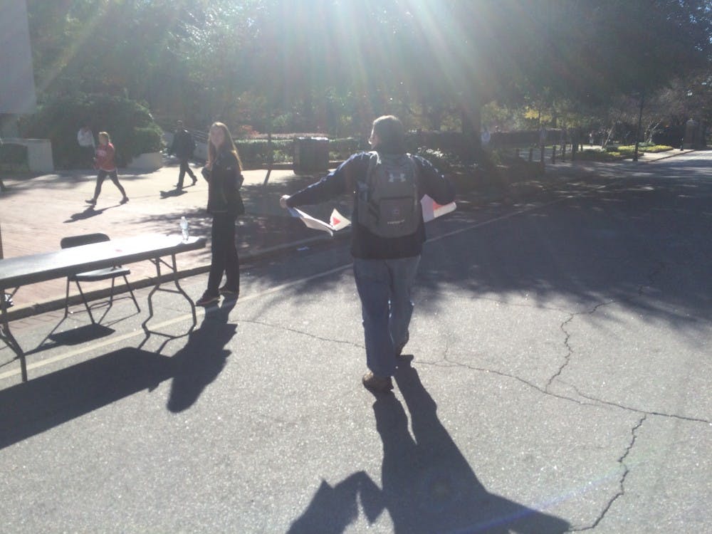 Fourth-year history student Louis Cook tears up a poster from the event on which a swastika was drawn. When asked why he did so, he said "You got a right to put one up. Put it up on your house, not on our campus.”