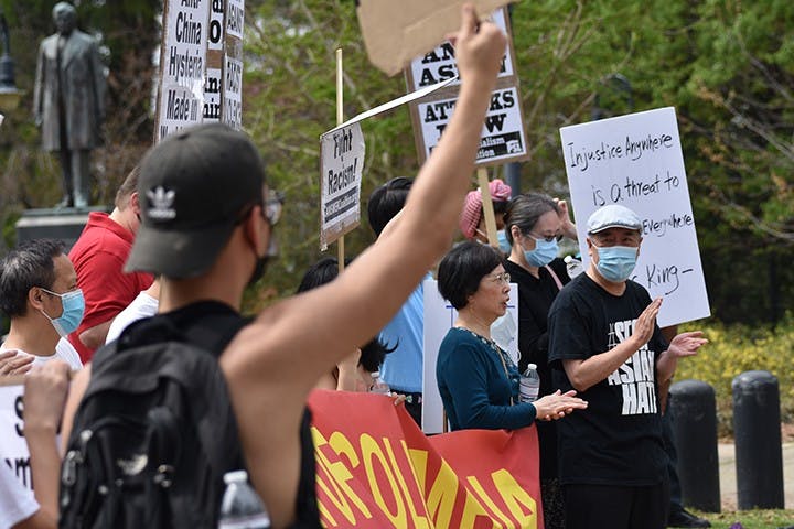 Photo 8: Protestors clap and cheer as cars pass by and honk in support of their cause, many people who drove by held a fist out their window in support.
