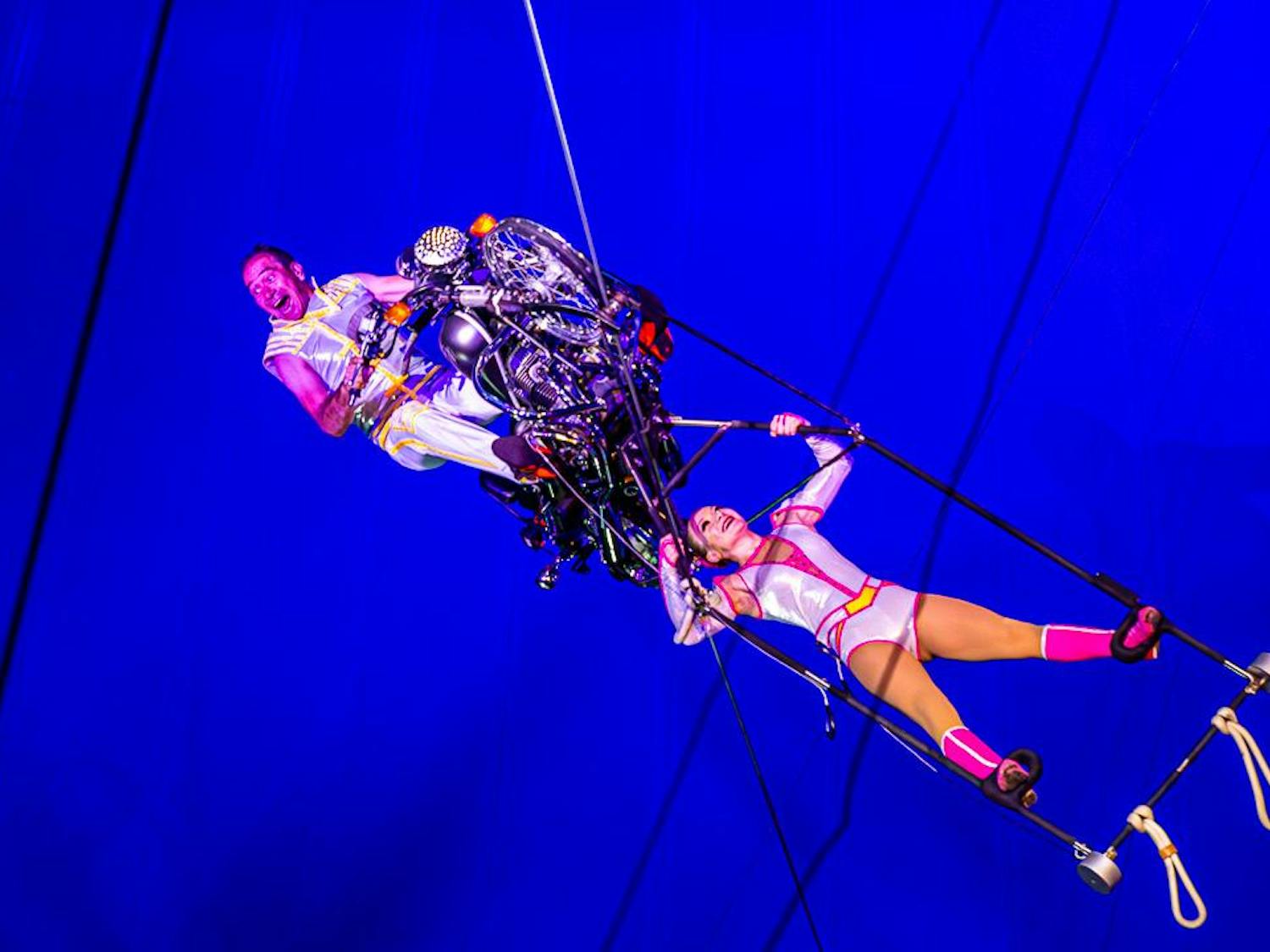Alex Petrov (left) beams while turning his motorcycle and daughter Sophia Petrov (right) upside down during the finale of the CIRCUS at the Fair on Oct. 18, 2023. The duo performs acrobatic stunts while driving a motorcycle on a wire above the ring.