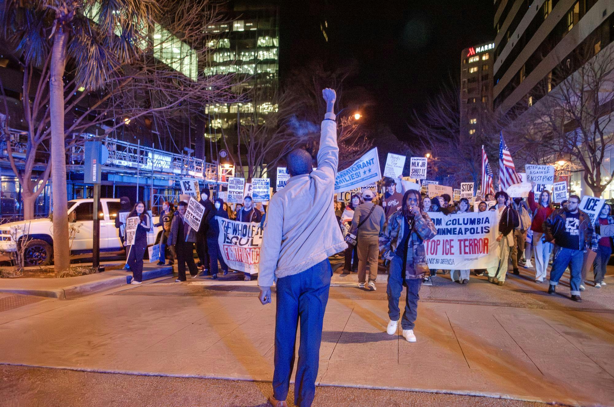Kenneth J. E. Jones Jr. raises a fist to the crowd as it marches back to the statehouse from Columbia City Hall on Jan. 20, 2026. The banners they hold promote the Party for Socialism and Liberation and Midlands SC Defensa, who run an ICE sighting hotline.