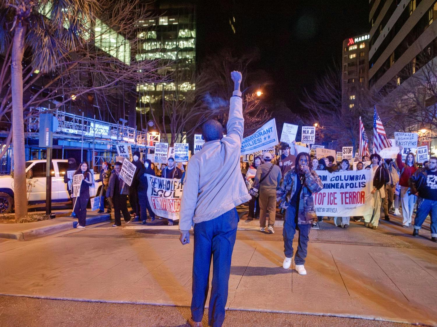 Kenneth J. E. Jones Jr. raises a fist to the crowd as it marches back to the statehouse from Columbia City Hall on Jan. 20, 2026. The banners they hold promote the Party for Socialism and Liberation and Midlands SC Defensa, who run an ICE sighting hotline.