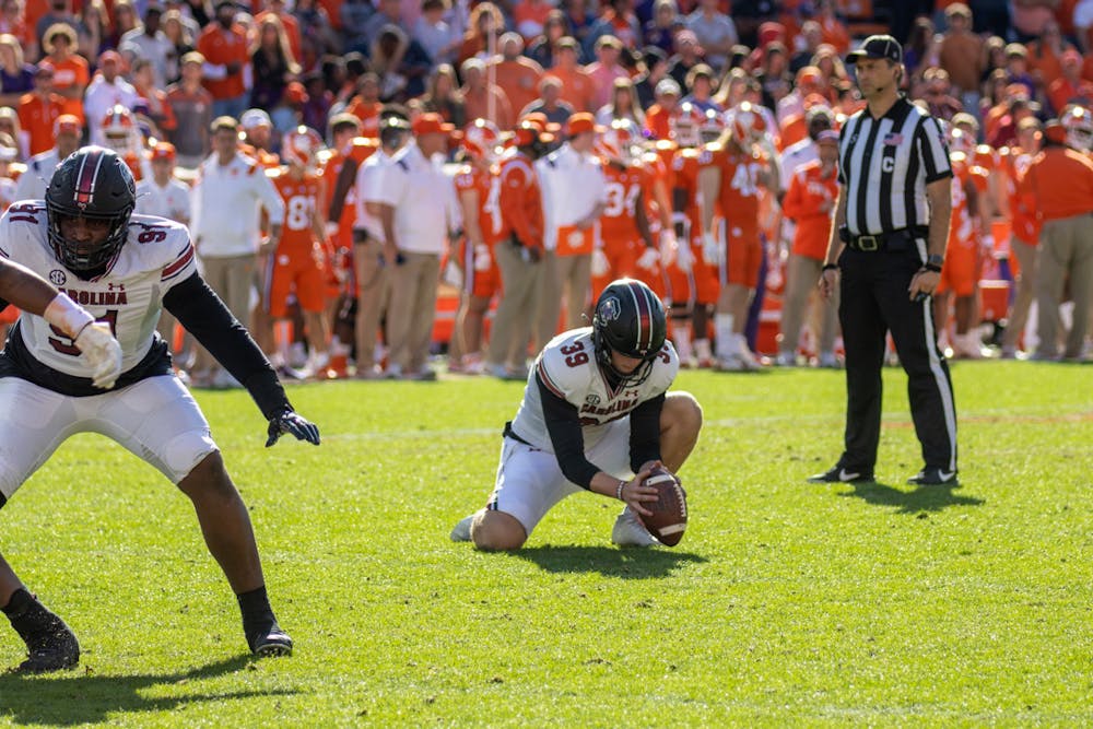 Junior punter Kai Kroeger lining up the ball for a place kick by junior placekicker Mitch Jeter on Nov. 26, 2022 at Memorial Stadium. The Gamecocks scored on all attempted field goals against Clemson.