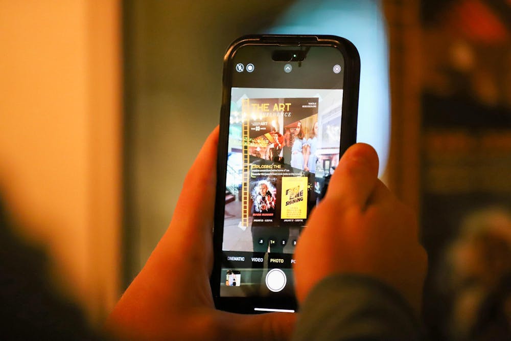 <p>A person uses a smartphone to take a photo of a poster outside of the Nickelodeon Theatre at 1607 Main St. in Columbia, SC on Jan. 17, 2024. The poster advertises the double feature of "Blade Runner" and "The Shining."</p>